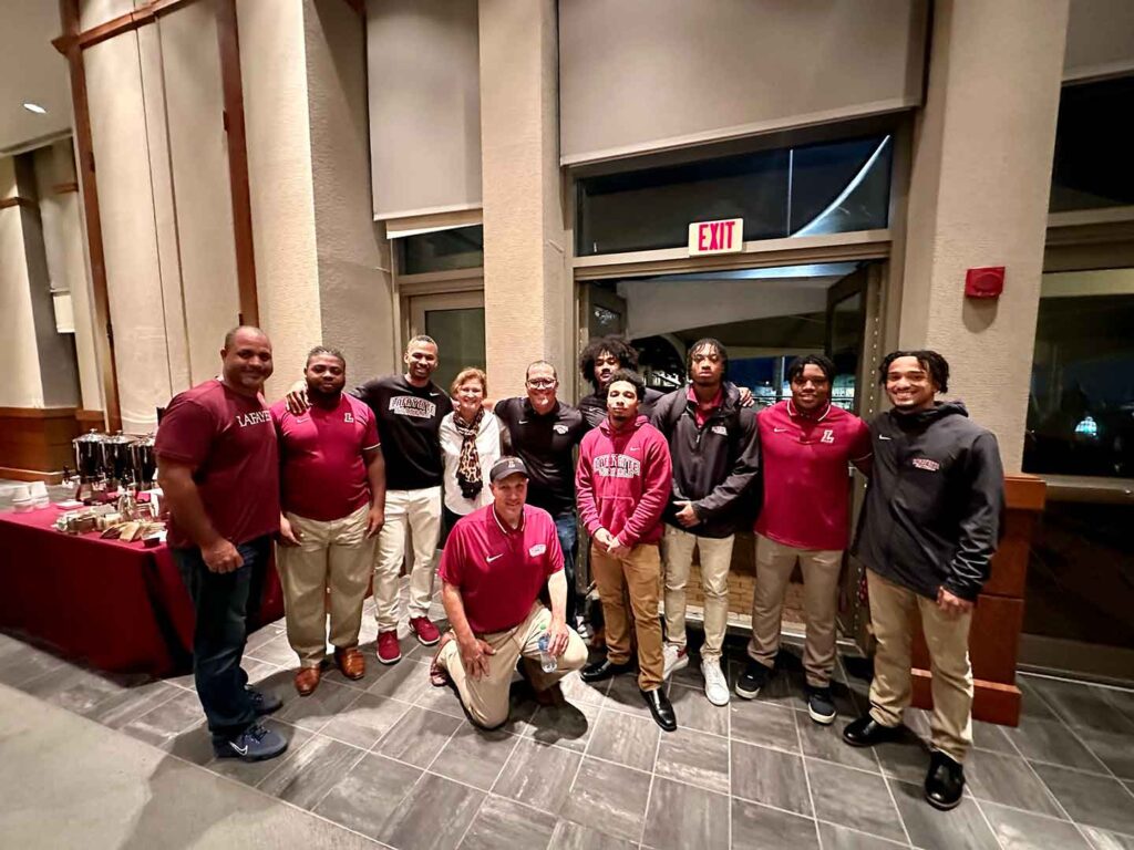 President Nicole Hurd with members of the football team and football alumni. 